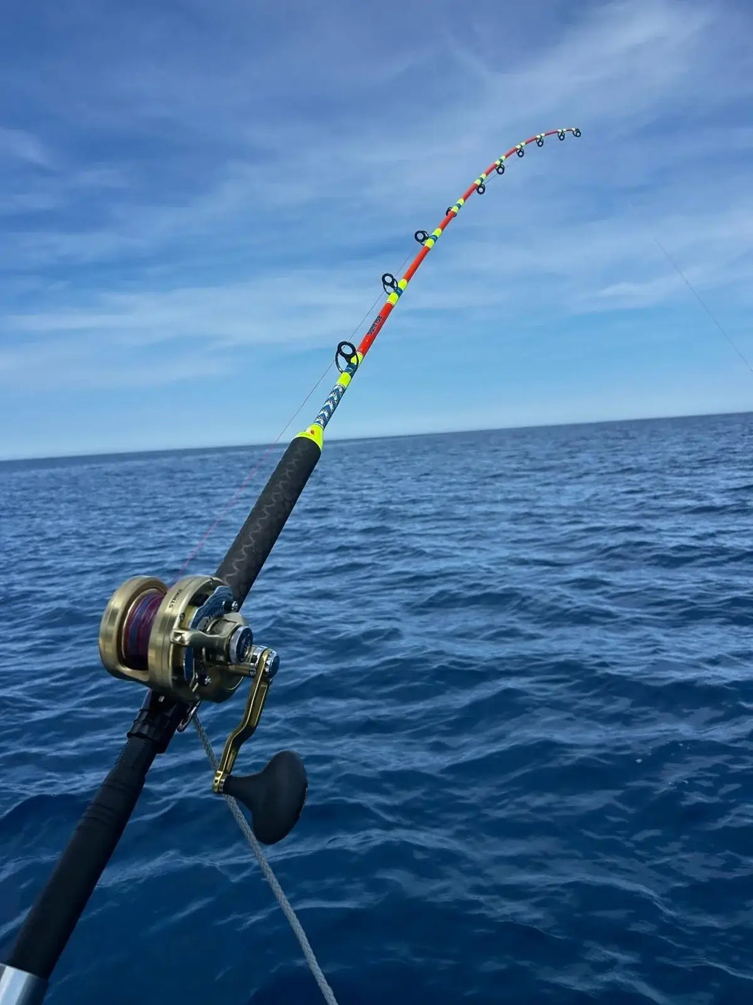 Image of a fishing rod bent over the sea, illustrating La Traîne lente au Vif : La technique des vrais pêcheurs  mediterranéens.
