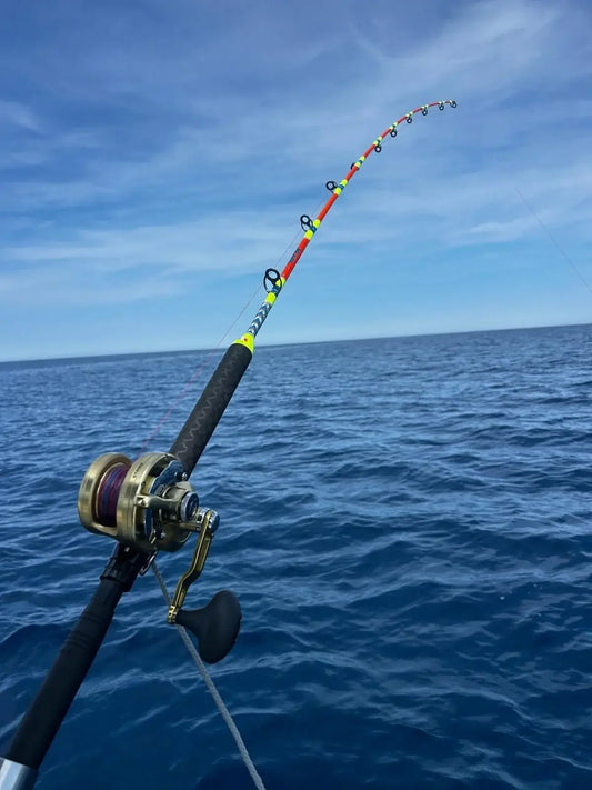 Image of a fishing rod bent over the sea, illustrating La Traîne lente au Vif : La technique des vrais pêcheurs  mediterranéens.