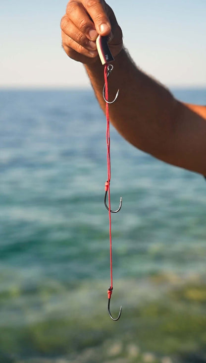 ISULA BAIT ®  Fireball -- Denti Pagre Sériole - close-up of fishing hooks with red line, ideal for sea fishing.
